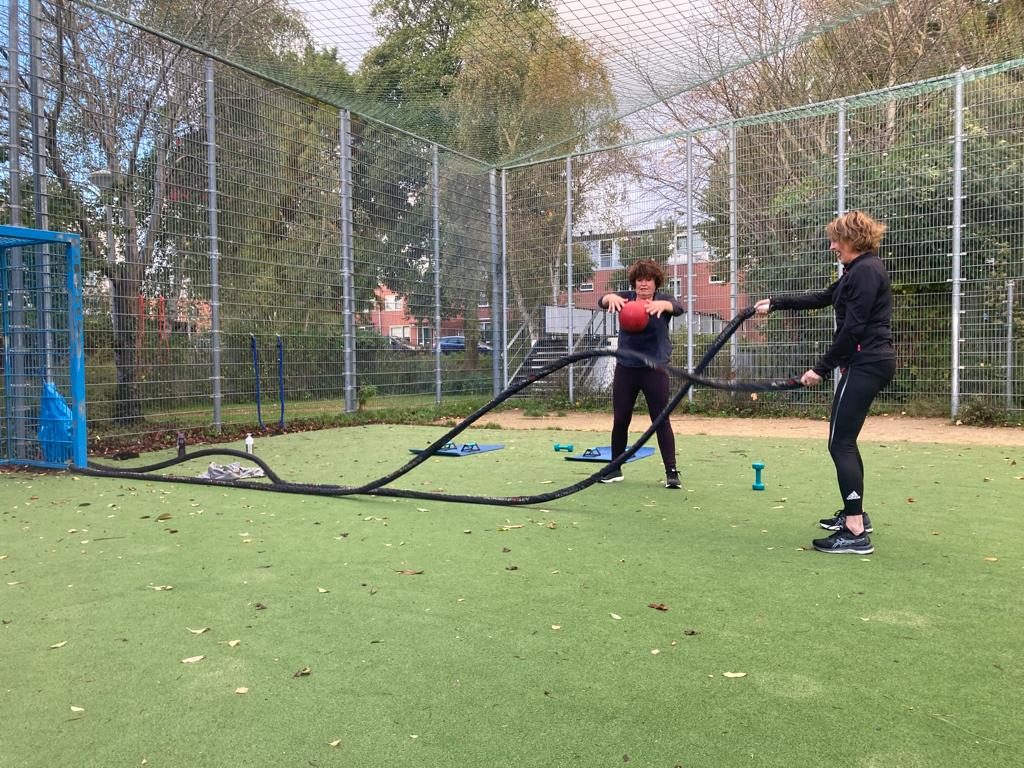 Twee vrouwen trainen met touwen op een veld